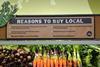 US retail Wholefoods reasons to buy local sign above carrots Â© Michael Worthington