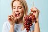 Generic woman eating grapes Adobe