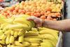 Picking up bananas in supermarket Adobe Stock