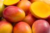 Whole and halved mangoes close up Adobe Stock