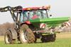 Mit Hilfe eines Traktors wird ein Feld gedüngt