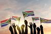 Hands waving South African flags Adobe