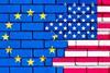 EU and US flags on brick wall Adobe Stock