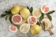 Cut and whole pomelos on marble surface