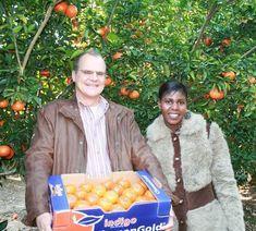 Abraham Van Rooyen and Kate Hlongo of Indigo Farming in the ClemenGold orchard with a carton of ClemenGold packed in the Indigo Brand