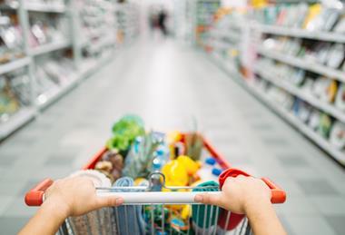 Kunde schiebt Einkaufswagen durch den Supermarkt