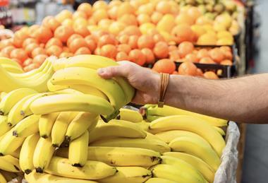 Picking up bananas in supermarket Adobe Stock