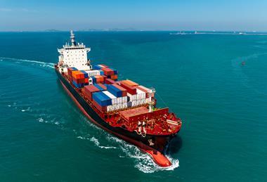 Ein Containerschiff läuft in einen Hafen ein