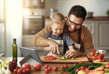 Father and child cutting and preparing vegetables Adobe Stock