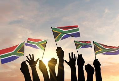 Hands waving South African flags Adobe