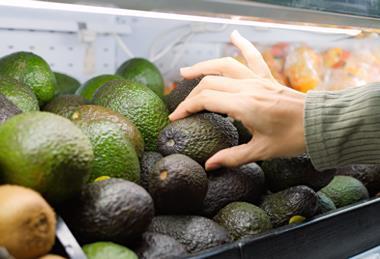 Shopper buying avocado Adobe Stock