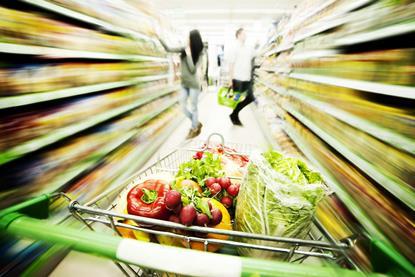 GEN trolley full of fresh produce in supermarket alley
