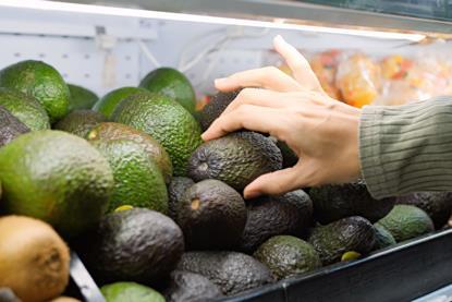 Shopper buying avocado Adobe Stock