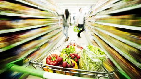 GEN trolley full of fresh produce in supermarket alley