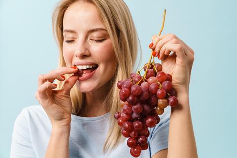 Generic woman eating grapes Adobe
