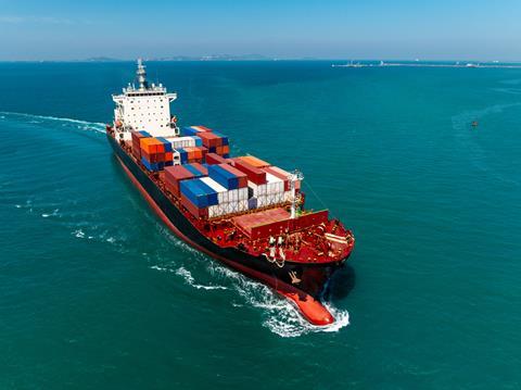 Ein Containerschiff läuft in einen Hafen ein