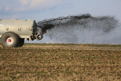 Auf einem Feld wird Dünger ausgebracht