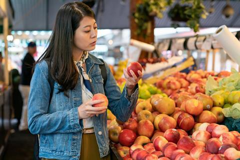 Woman buying organic fruit US Adobe