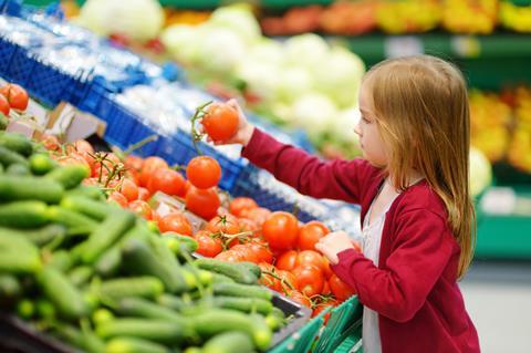 Mädchen greift im Supermarkt bei Tomaten zu - MNStudio_AdobeStock