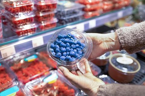 Blueberry punnet in retailer held Adobe