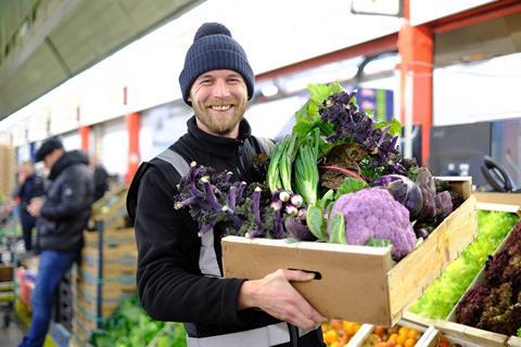 Wholesale market employee holding box of veg