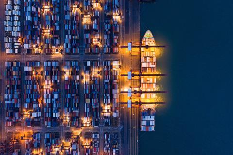 Container ship at port in Hong Kong by night Adobe