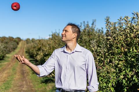 Farmer throwing apple in front of Orchard Virginia USA