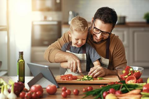 Father and child cutting and preparing vegetables Adobe Stock