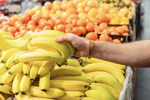 Picking up bananas in supermarket Adobe Stock