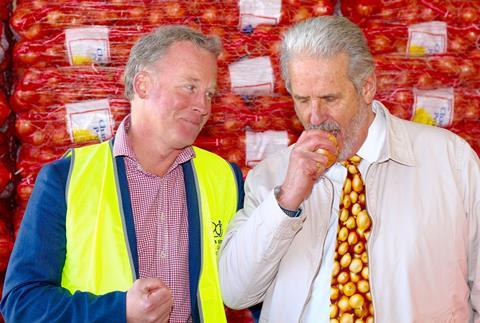 Tas. Premier Will Hodgman watches Ian Locke bite into a raw onion